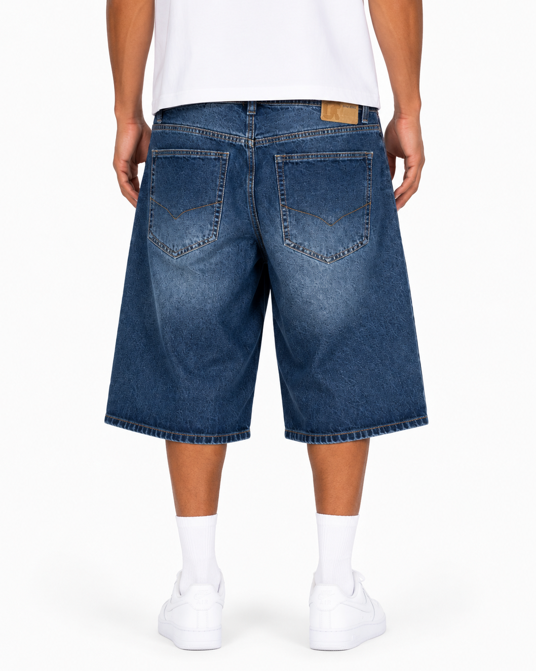 Person wearing blue denim shorts on a white background