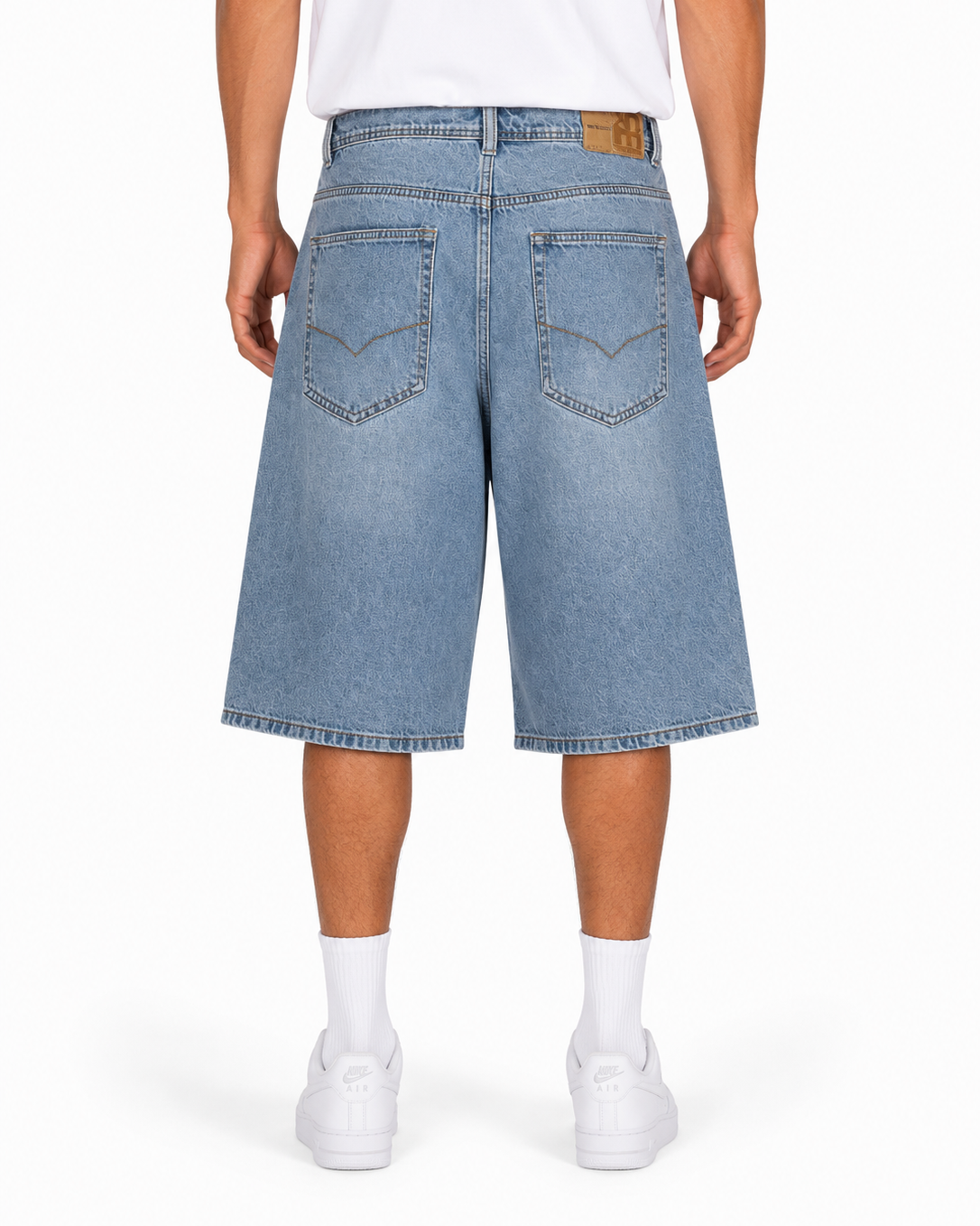 Person wearing light blue denim shorts on a white background