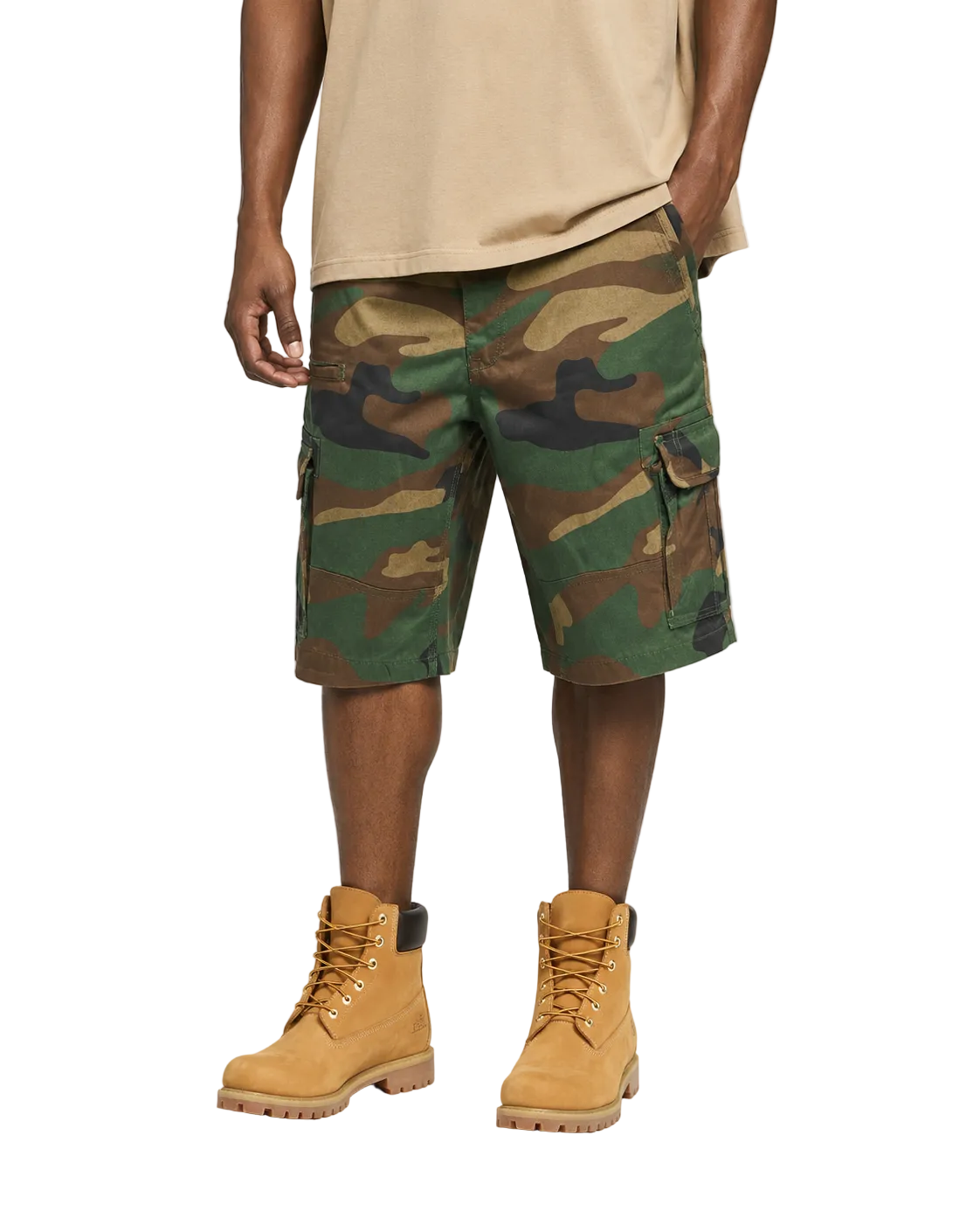 Person wearing camouflage cargo shorts and tan boots on a white background