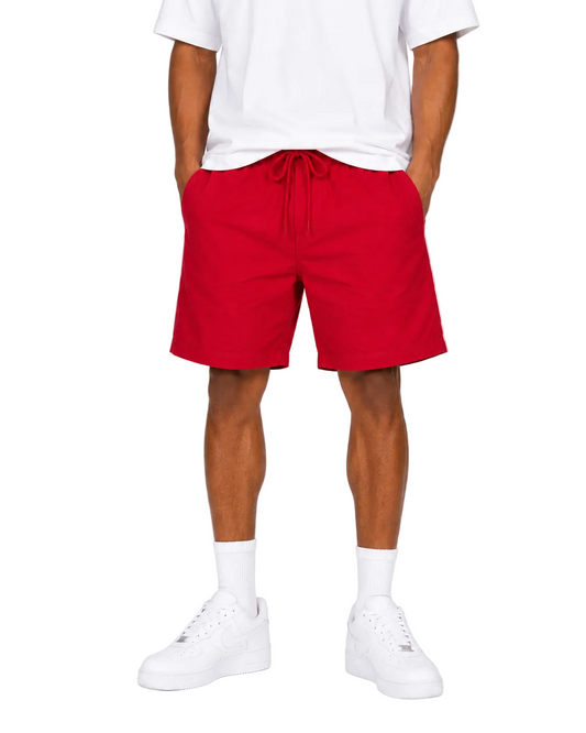 Person wearing red shorts and white sneakers on a white background
