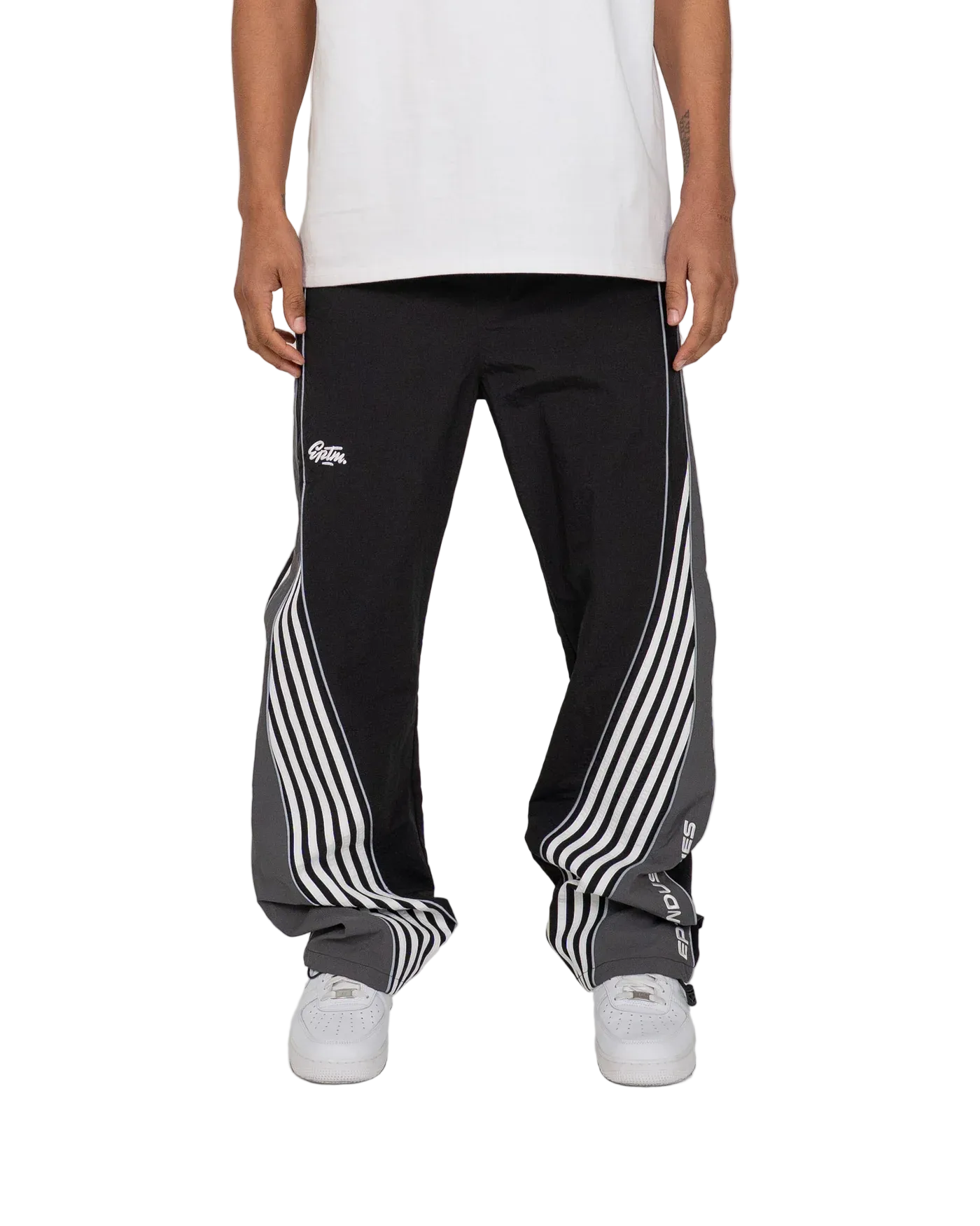 Person wearing black track pants with white stripes and a brand logo on a white background