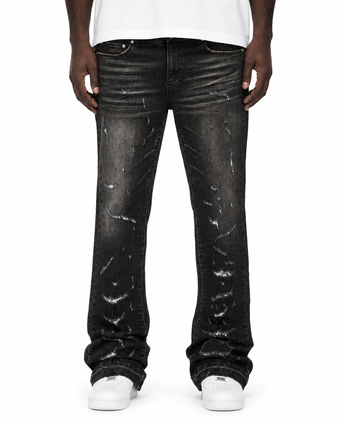 Person wearing black distressed jeans and a white shirt on a white background