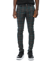 Man model wearing skinny fit grey and blue plaid pants with black and white Alexander Mcqueen sneakers