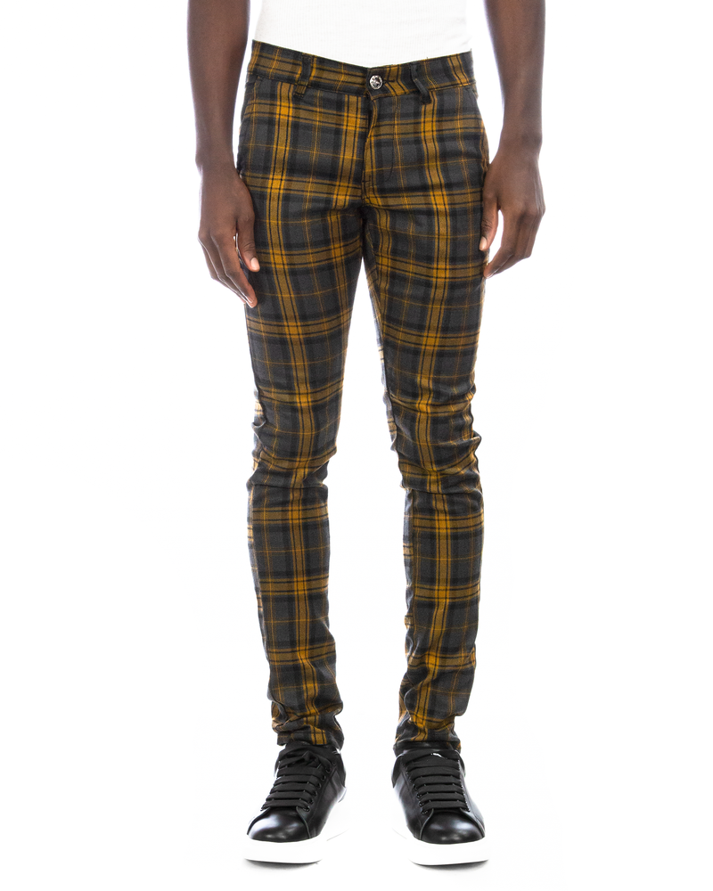Man model wearing skinny fit yellow plaid pants with black and white Alexander Mcqueen sneakers